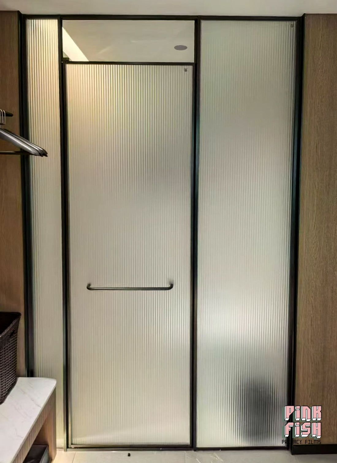 Modern shower enclosure with frosted ribbed glass door in a bathroom setting