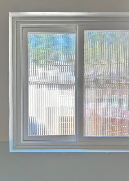 Window with reeded window film, showing a blurred outdoor scene.