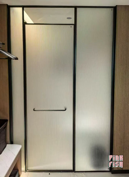Modern shower enclosure with frosted ribbed glass door in a bathroom setting