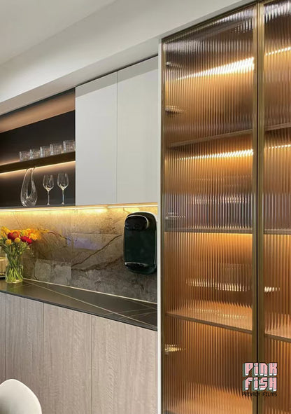 Modern kitchen with Amber coloured reeded glass window film on glassware cabinet and countertop setup